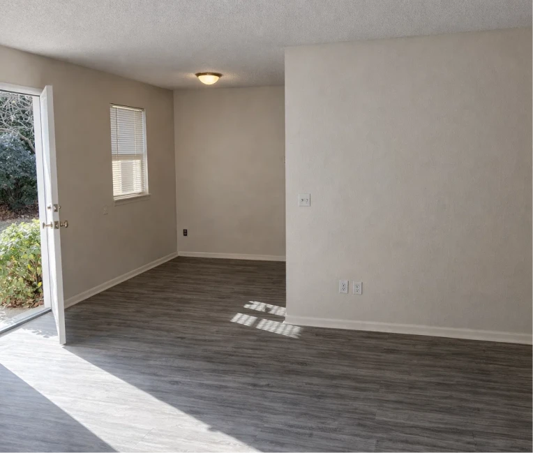 Open-concept living room with grey plank floors and natural light in 1, 2, 3 bedroom apartments El Reno.