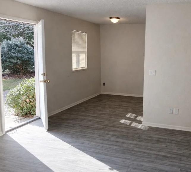 Modern living area with wood-style flooring and natural light in El Reno apartments with easy access to I-40 and Route 66.
