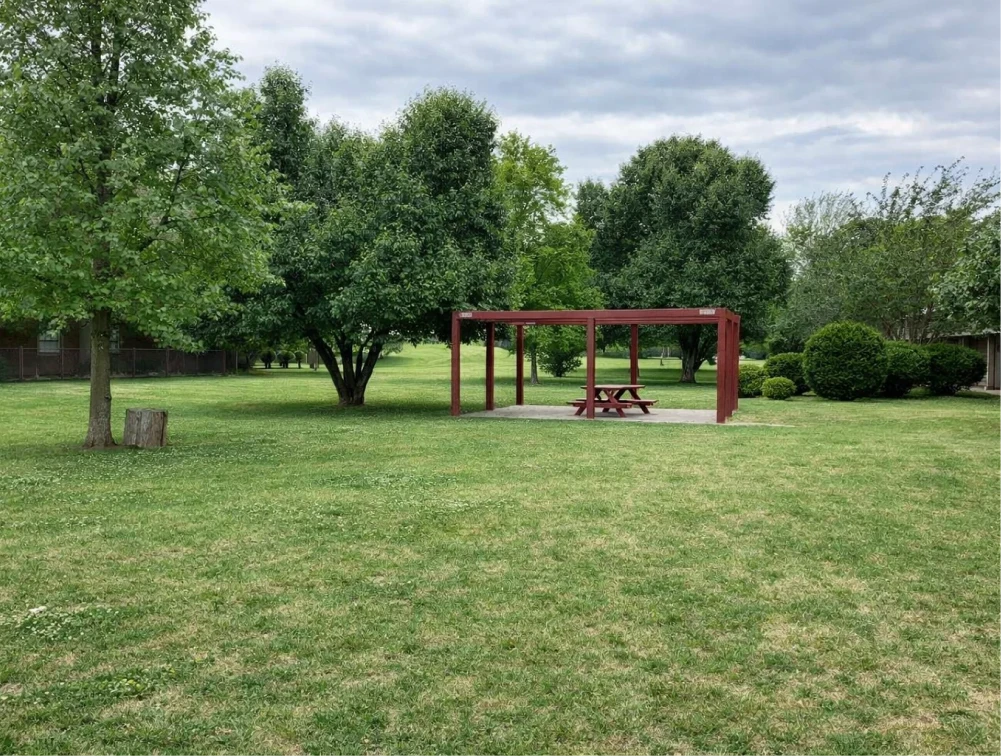 Wide green lawn and shaded picnic area at pet-friendly apartments in El Reno, OK.