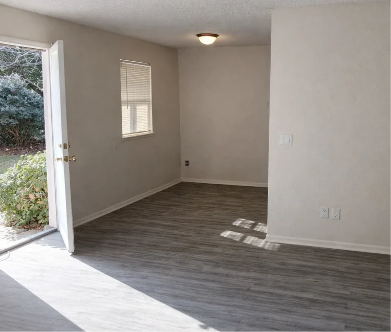Sunlit entryway and living room with modern wood-style flooring in affordable apartments near Oklahoma City.