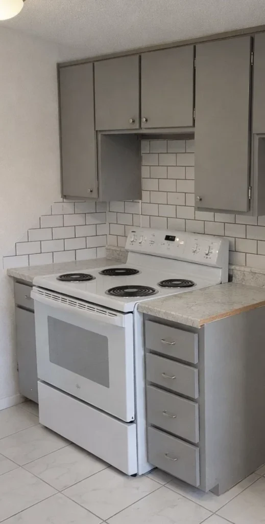 White electric stove and oven surrounded by grey cabinetry in utilities included apartments El Reno.